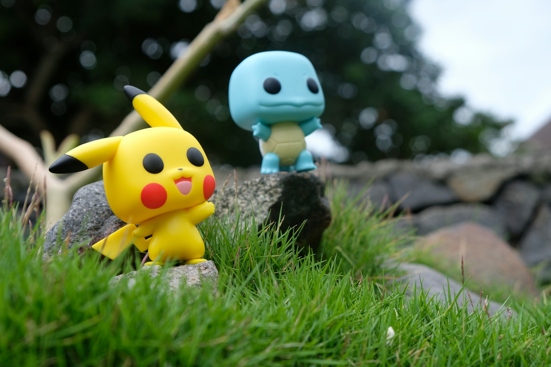 yellow pokemon and blue toy on grass