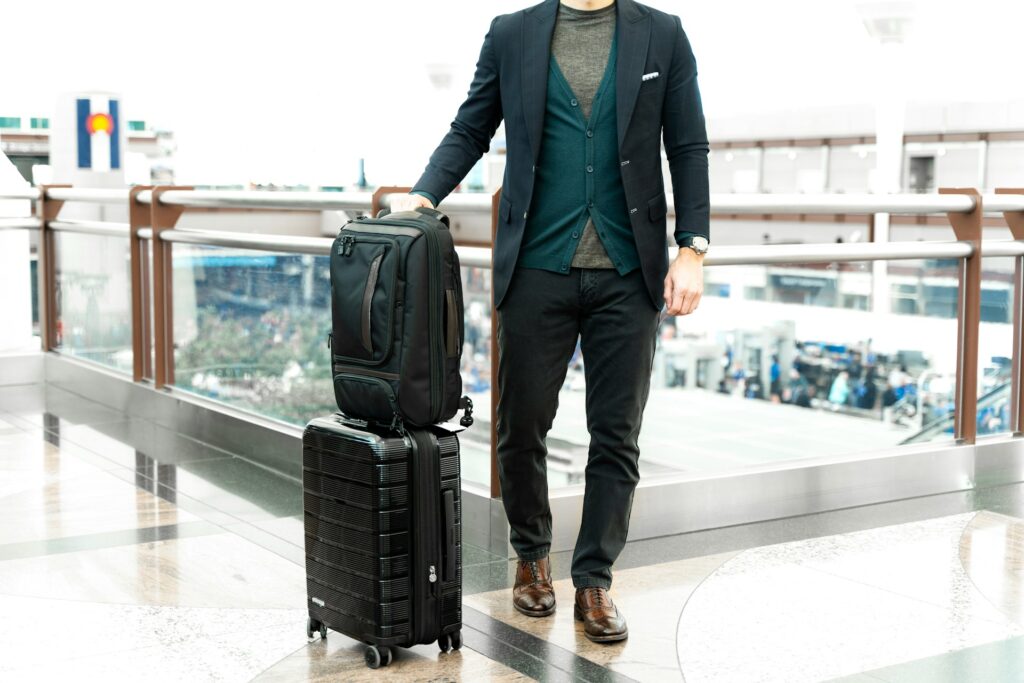 A traveller holding a suitcase with a carry on bag
