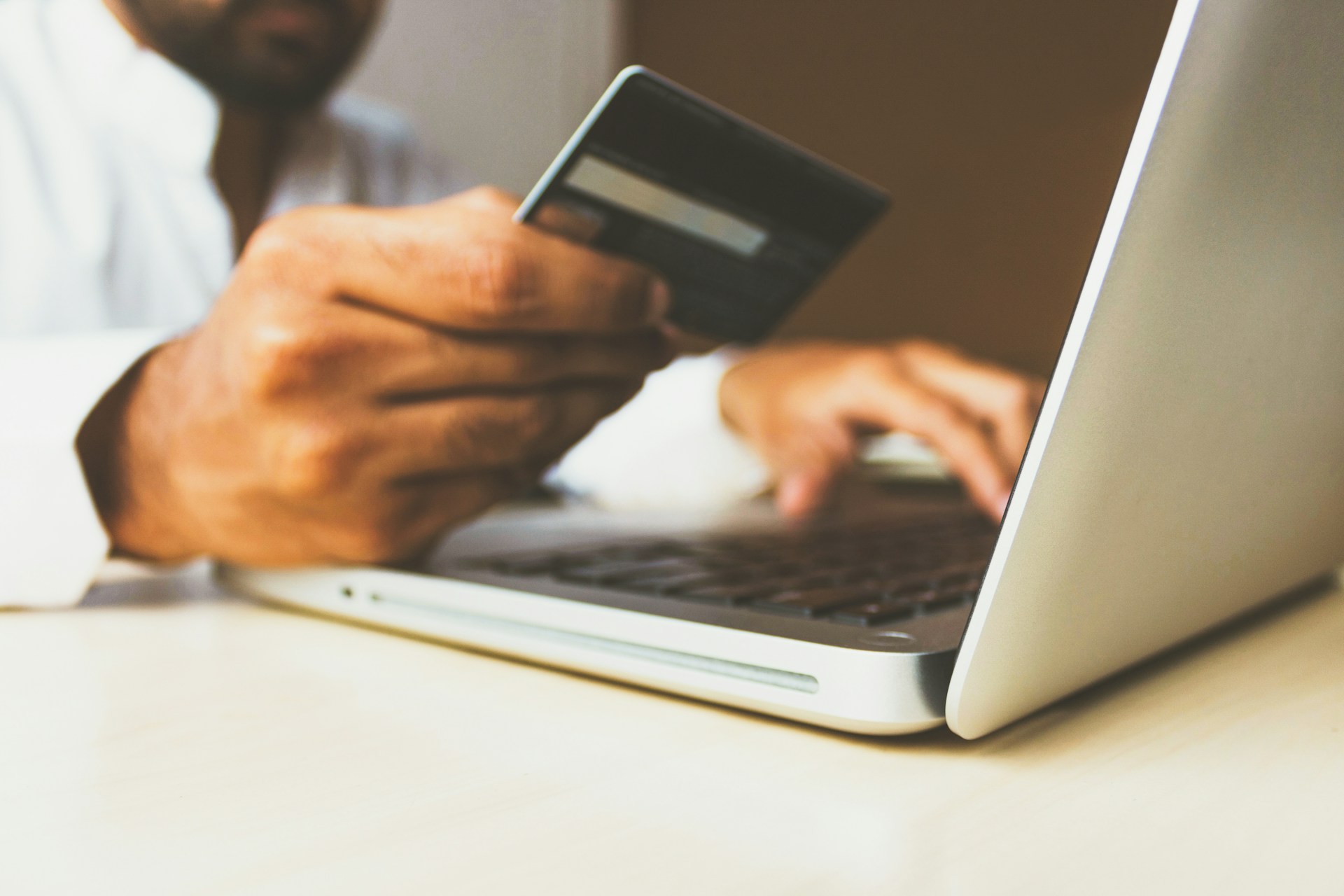 A person holding a debit card while shopping online