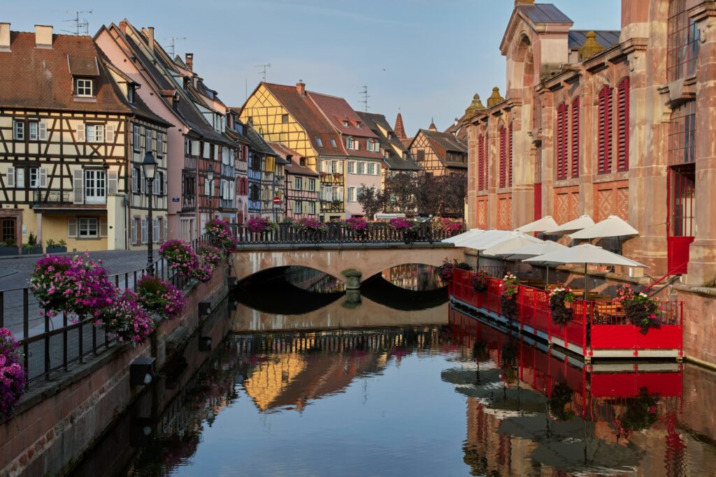 A street in Colmar, with a canal in the middle and colourful buildings