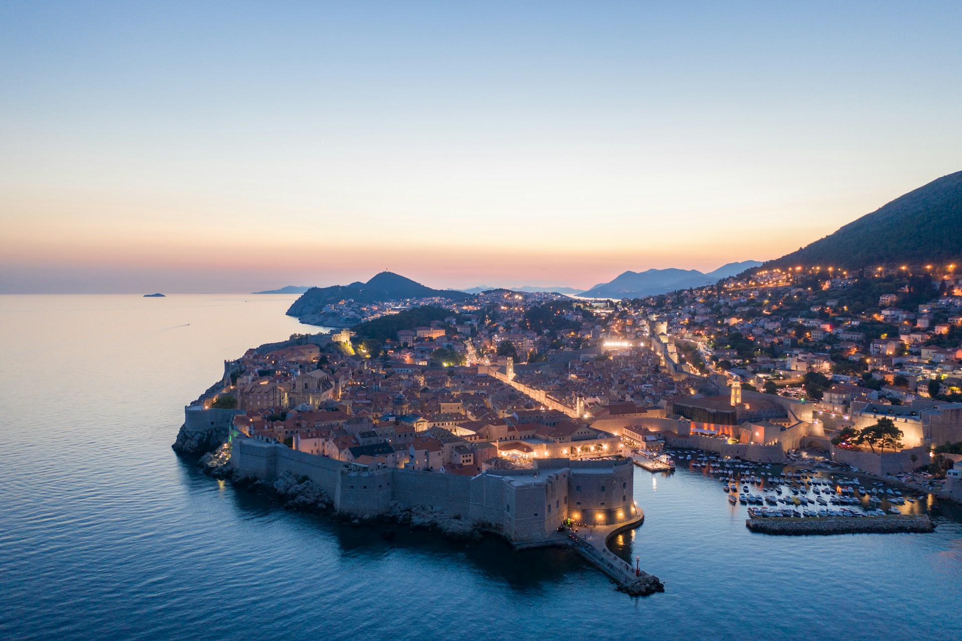 The bay of Dubrovnik at sunset, with street lights forming a glow