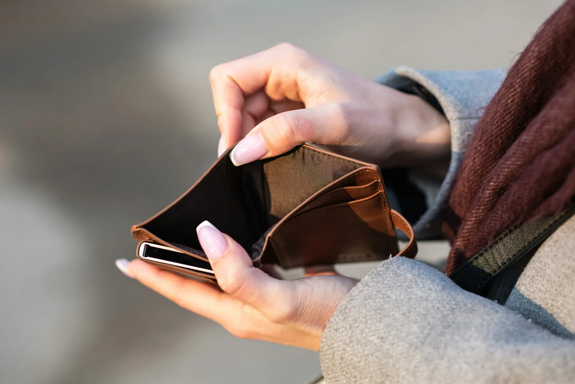 A person holding open an empty wallet