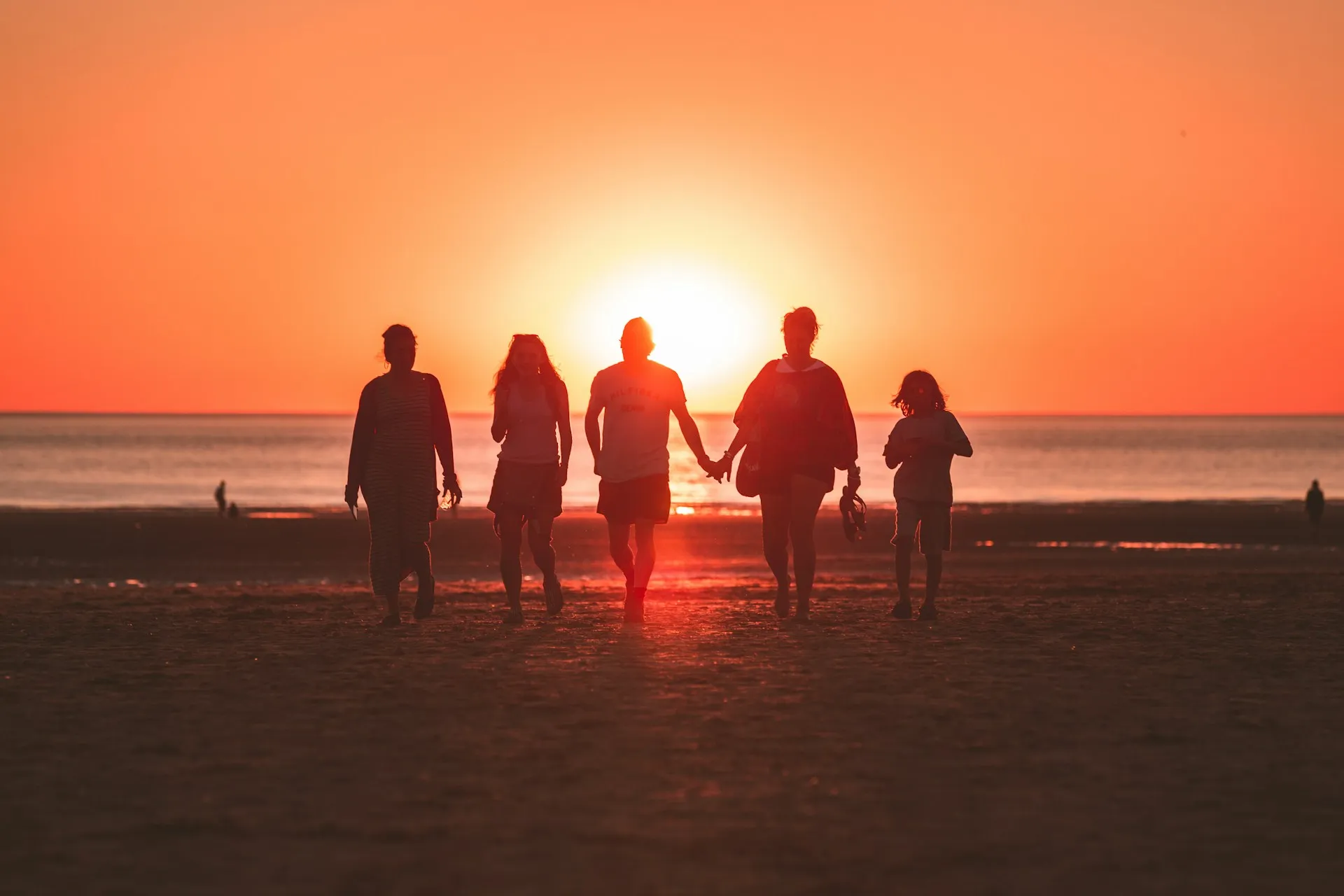 A family walking into a sunset on a beach