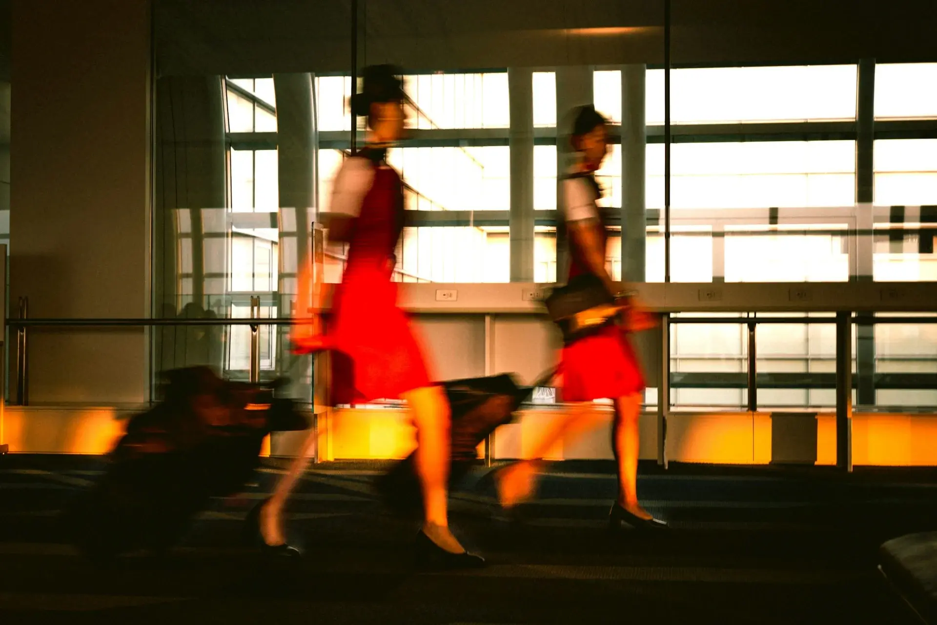 2 women walking and pulling suitcases
