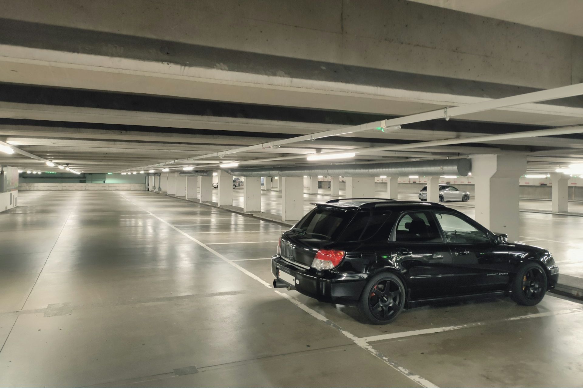 A black car in a well-lit car park