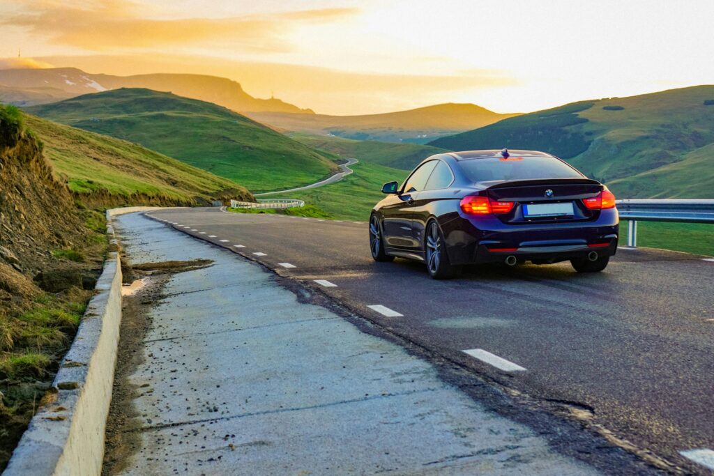 A black car driving along the road